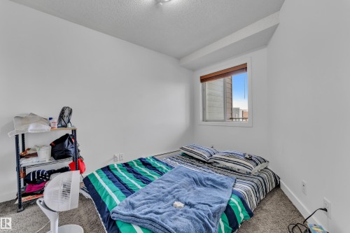 Carpeted room with a single window, white walls, and a built-in ceiling light fixture - #409 11804 22 Av Sw, Edmonton, AB - Indoor Photo Showing Bedroom