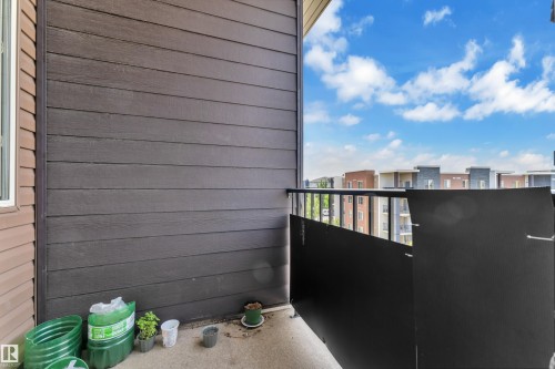 Balcony featuring concrete flooring, black metal railing, and horizontal siding - #409 11804 22 Av Sw, Edmonton, AB - Outdoor With Balcony With Exterior