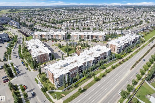 Multi-story residential buildings with surface parking areas and surrounding green spaces - #409 11804 22 Av Sw, Edmonton, AB - Outdoor With View