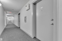 Corridor with modern patterned carpet, recessed wall lighting, and apartment entry doors - 