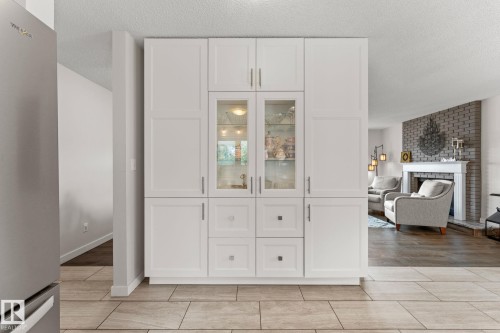 White built-in cabinetry with glass-front display cabinets, various storage configurations, and brushed nickel hardware - 34 Stirling Road Nw, Edmonton, AB - Indoor Photo Showing Other Room