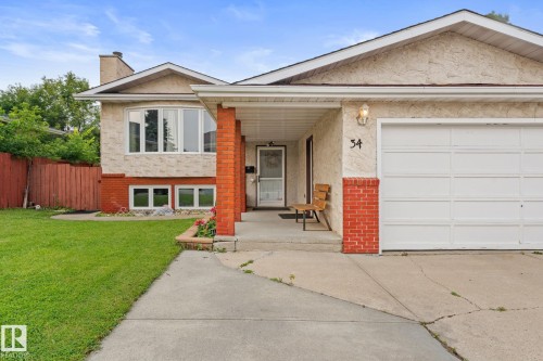 Front exterior featuring a single-car garage, concrete driveway, and a covered entryway - 34 Stirling Road Nw, Edmonton, AB - Outdoor
