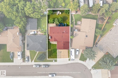 Red-roofed residence featuring a spacious backyard with a green lawn, mature trees, and an elevated deck - 34 Stirling Road Nw, Edmonton, AB - Other