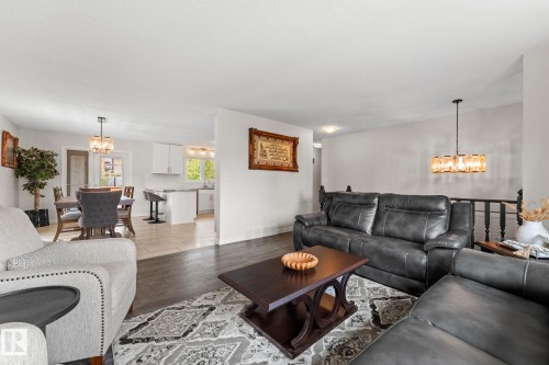 Living area featuring dark wood-finish flooring and a decorative area rug - 34 Stirling Road Nw, Edmonton, AB - Indoor Photo Showing Living Room