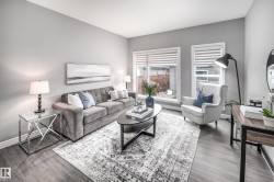 Wood-finish flooring throughout, light gray wall paint, and two large windows with blinds - 