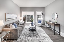 Recessed lighting illuminates the living area featuring wood-finish flooring, white window blinds, and a built-in wall mirror - 