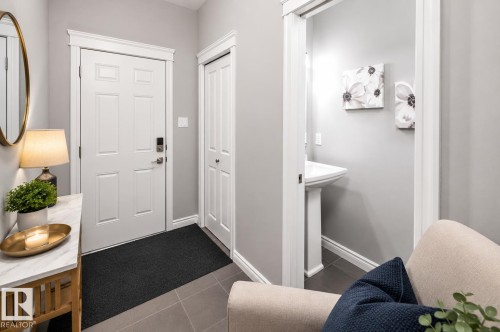 Entryway featuring a paneled door with smart lock, adjacent closet, and tile flooring - 16015 11 Avenue Sw, Edmonton, AB - Indoor Photo Showing Other Room