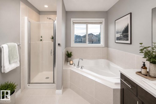 Corner soaking tub with tile surround, separate enclosed shower, and a single window for natural light - 16015 11 Avenue Sw, Edmonton, AB - Indoor Photo Showing Bathroom
