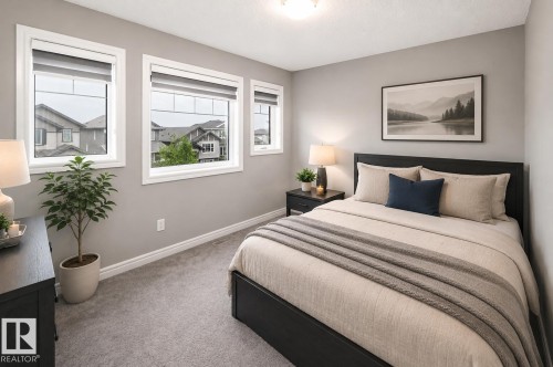 Three white-framed windows, light gray wall paint, and gray carpet flooring - 16015 11 Avenue Sw, Edmonton, AB - Indoor Photo Showing Bedroom