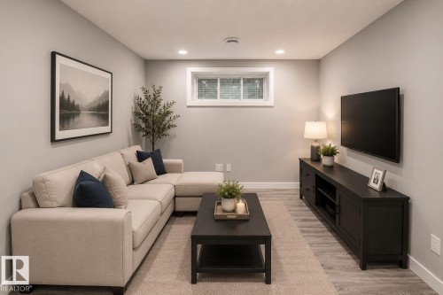Recessed lighting illuminates this room featuring light gray walls, wood-finish flooring, and a white-framed window - 16015 11 Avenue Sw, Edmonton, AB - Indoor Photo Showing Living Room
