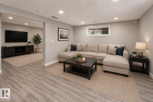 Wood-finish flooring throughout, recessed lighting, and a window with white trim - 16015 11 Avenue Sw, Edmonton, AB - Indoor