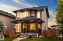 Two-story home with stone column accents, neutral-toned siding, and a dark shingle roof - 16015 11 Avenue Sw, Edmonton, AB  - Outdoor 