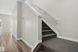 Staircase featuring patterned carpet treads and white handrails - 