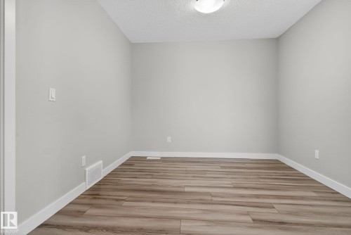 Recessed ceiling light fixture, wood-finish flooring, and light gray wall paint - 4879 Alwood Point(E) Sw, Edmonton, AB - Indoor Photo Showing Other Room