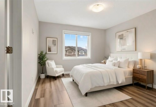 Wood-finish flooring with light-toned walls, a large window, and a flush mount ceiling light - 4879 Alwood Point(E) Sw, Edmonton, AB - Indoor Photo Showing Bedroom
