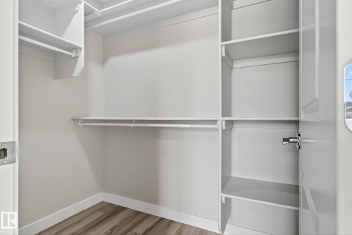 Built-in closet shelving, multiple hanging rods, durable wood-finish flooring - 4879 Alwood Point(E) Sw, Edmonton, AB - Indoor With Storage