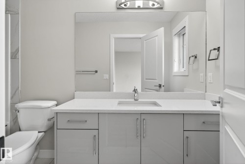Vanity with a light gray cabinet, white countertop, integrated sink, and chrome faucet - 4879 Alwood Point(E) Sw, Edmonton, AB - Indoor Photo Showing Bathroom