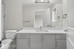 Vanity with a light gray cabinet, white countertop, integrated sink, and chrome faucet - 