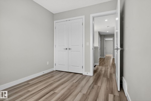 Wood-finish flooring, light gray wall paint, and white trim - 4879 Alwood Point(E) Sw, Edmonton, AB - Indoor Photo Showing Other Room