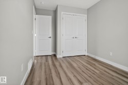 Light-toned walls, wood-finish flooring, white doors with panel detailing, and recessed ceiling lighting - 
