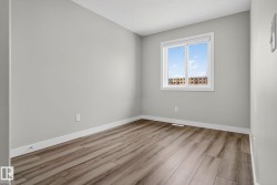 Wood-finish flooring, white window trim, and light grey wall paint - 