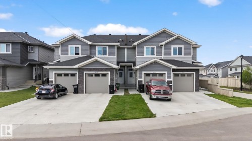 Modern two-story townhomes with gray siding and stone accents - 4879 Alwood Point(E) Sw, Edmonton, AB - Outdoor With Facade