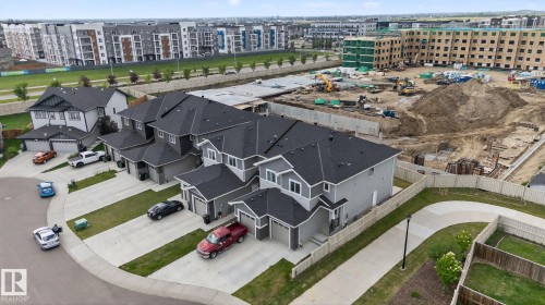 Residential neighborhood featuring detached and semi-detached homes, concrete driveways, and manicured lawns - 4879 Alwood Point(E) Sw, Edmonton, AB - Outdoor With View