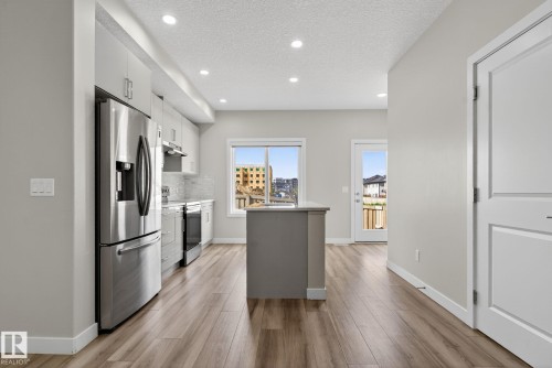 Kitchen featuring stainless steel appliances, wood-finish flooring, recessed lighting, and a center island - 4879 Alwood Point(E) Sw, Edmonton, AB - Indoor Photo Showing Kitchen