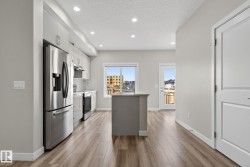 Kitchen featuring stainless steel appliances, wood-finish flooring, recessed lighting, and a center island - 
