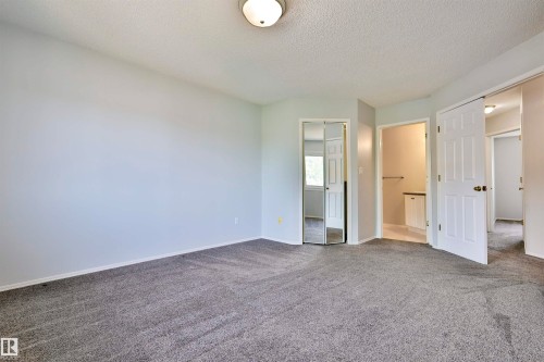 Neutral-toned walls complement the textured gray carpeting - 15529 95 Avenue Nw, Edmonton, AB - Indoor Photo Showing Other Room