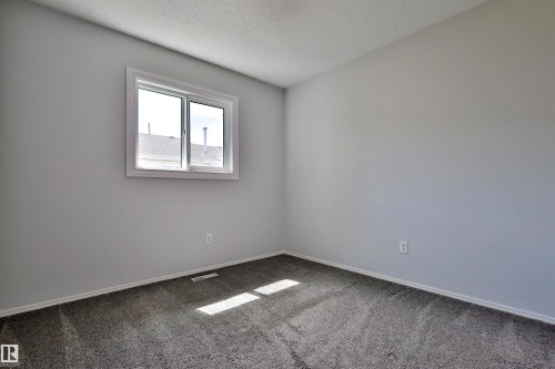 Neutral wall paint with textured ceiling, grey carpeting, and white trim - 15529 95 Avenue Nw, Edmonton, AB - Indoor Photo Showing Other Room