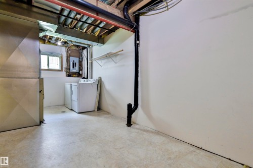 Basement utility area with exposed ceiling joists, durable flooring, a single window, and a wall-mounted electrical panel - 15529 95 Avenue Nw, Edmonton, AB - Indoor Photo Showing Laundry Room