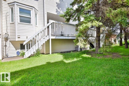Expansive grassy yard with mature trees, a multi-level deck, and bay window - 15529 95 Avenue Nw, Edmonton, AB - Outdoor