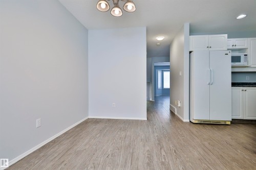 Open concept living space featuring wood-finish flooring, white cabinetry, and recessed lighting - 15529 95 Avenue Nw, Edmonton, AB - Indoor Photo Showing Other Room
