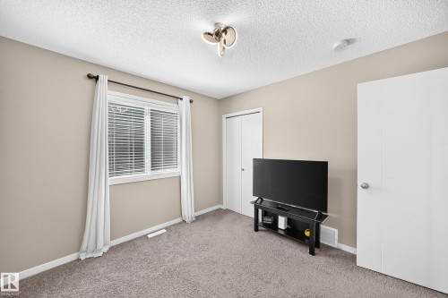 Textured carpeting, neutral wall color, and a window with blinds - 5147 Crabapple Link Sw, Edmonton, AB - Indoor