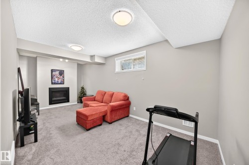 Recessed fireplace with hearth, wall-to-wall carpeting, and neutral wall tones - 5147 Crabapple Link Sw, Edmonton, AB - Indoor With Fireplace