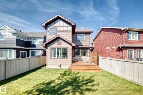 Expansive grassy lawn with a wood plank privacy fence and a multi-level wood deck - 5147 Crabapple Link Sw, Edmonton, AB - Outdoor