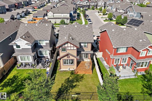 Manicured lawn with a wood deck, black metal fencing, and shingle roofing - 5147 Crabapple Link Sw, Edmonton, AB - Outdoor