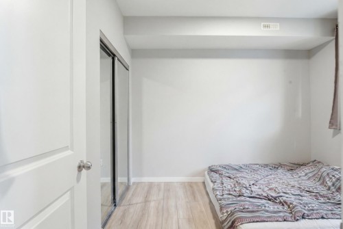 Light wood-finish flooring - #106 856 Secord Bv Nw Nw, Edmonton, AB - Indoor Photo Showing Bedroom