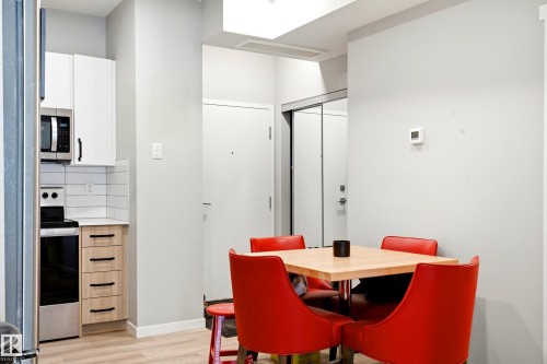Kitchenette featuring stainless steel appliances, white subway tile backsplash, and light wood-finish cabinetry - #106 856 Secord Bv Nw Nw, Edmonton, AB - Indoor Photo Showing Dining Room