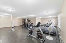 Dedicated fitness area featuring durable dark flooring, multiple windows, and recessed ceiling lighting - 