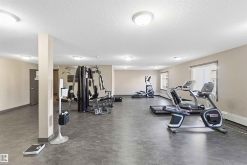 Dedicated fitness room featuring durable flooring, multiple windows, and recessed lighting - #114 2207 44 Av Nw, Edmonton, AB - Indoor Photo Showing Gym Room