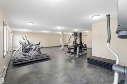 Fitness room featuring a multi-station weight machine, cardio equipment, and durable concrete-finish flooring - 