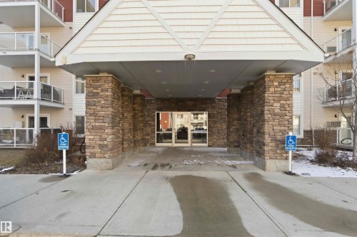 Building exterior featuring a stone-clad entrance with a covered portico - #114 2207 44 Av Nw, Edmonton, AB - Outdoor