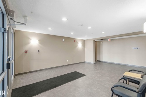 Spacious common area featuring durable tile flooring, recessed ceiling lighting, and contemporary wall sconces - #114 2207 44 Av Nw, Edmonton, AB - Indoor Photo Showing Other Room