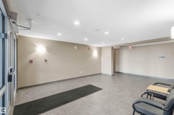 Spacious common area featuring durable tile flooring, recessed ceiling lighting, and contemporary wall sconces - 
