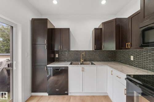 Contrasting cabinetry with gold-toned hardware - 10825 93 Street Nw, Edmonton, AB - Indoor Photo Showing Kitchen