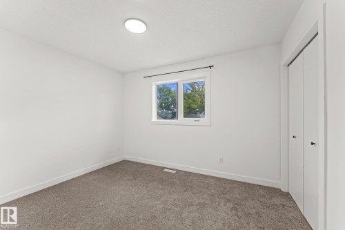 White walls, carpet flooring, and a single window with a dark rod - 10825 93 Street Nw, Edmonton, AB - Indoor Photo Showing Other Room