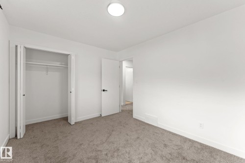 Neutral wall color, plush carpet flooring, white trim, bifold closet doors, and a ceiling-mounted light fixture - 10825 93 Street Nw, Edmonton, AB - Indoor Photo Showing Other Room
