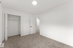 Neutral wall color, plush carpet flooring, white trim, bifold closet doors, and a ceiling-mounted light fixture - 